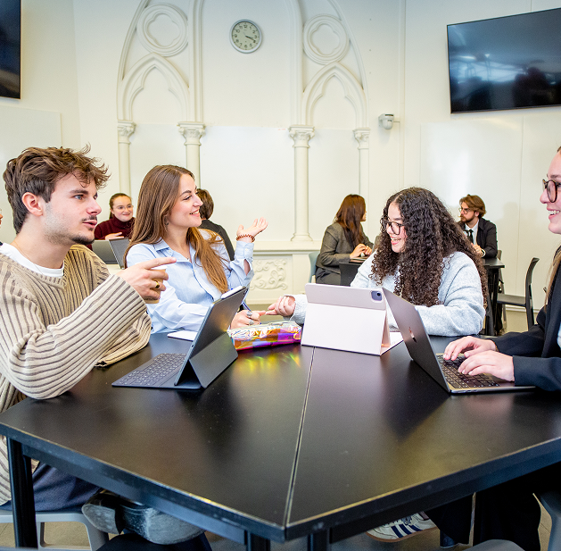 Une étudiante souriante se servant un repas au self-service d'un restaurant universitaire, accompagnée d'une autre étudiante.
